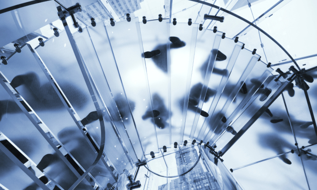 People walking on modern glass stairs seen from below